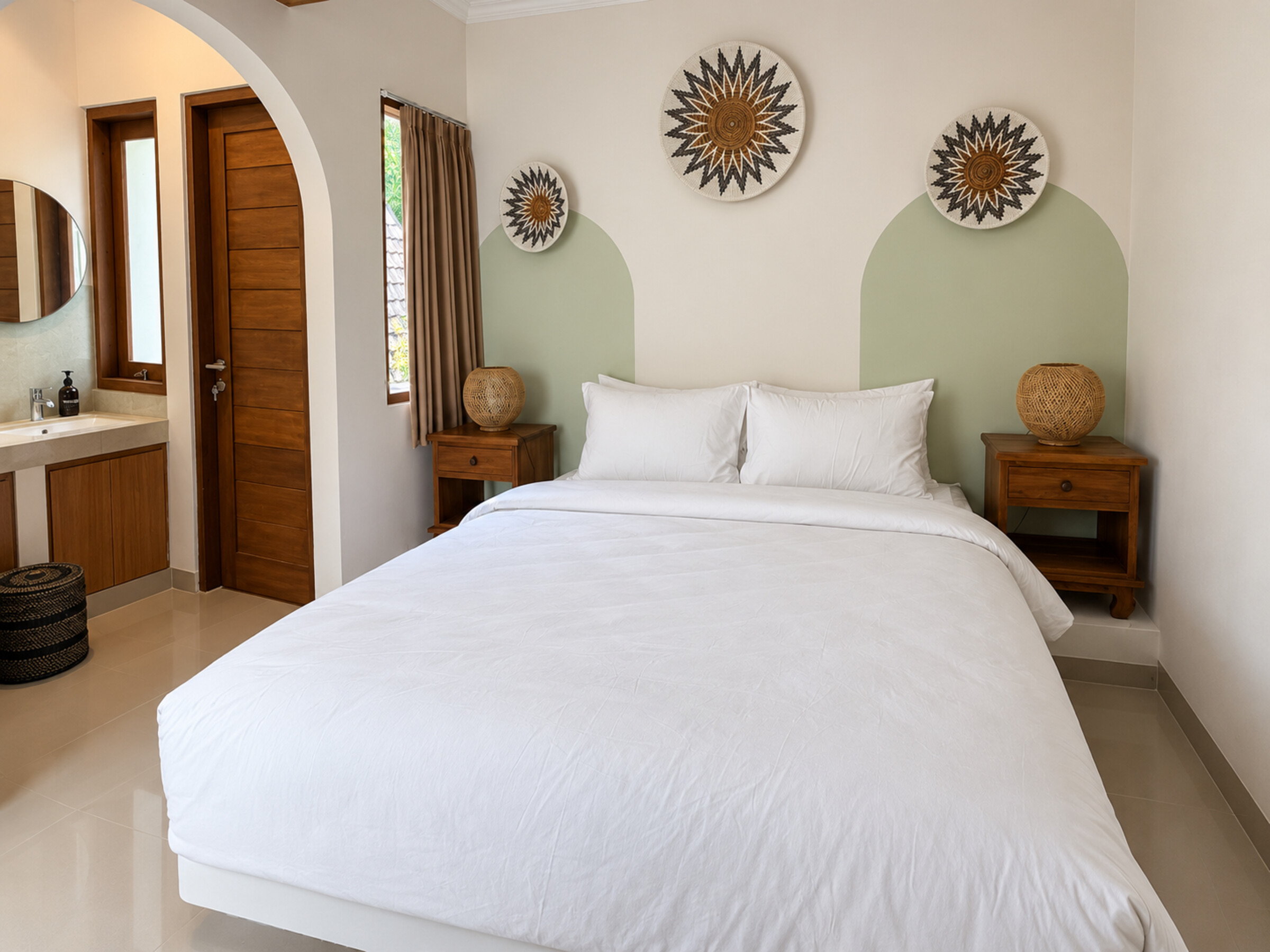 Double bed beside an arched vanity area and wooden door